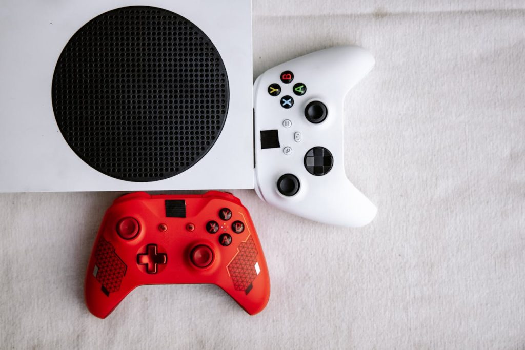 Close-up of red and white game controllers placed on a gaming console, top-view angle.