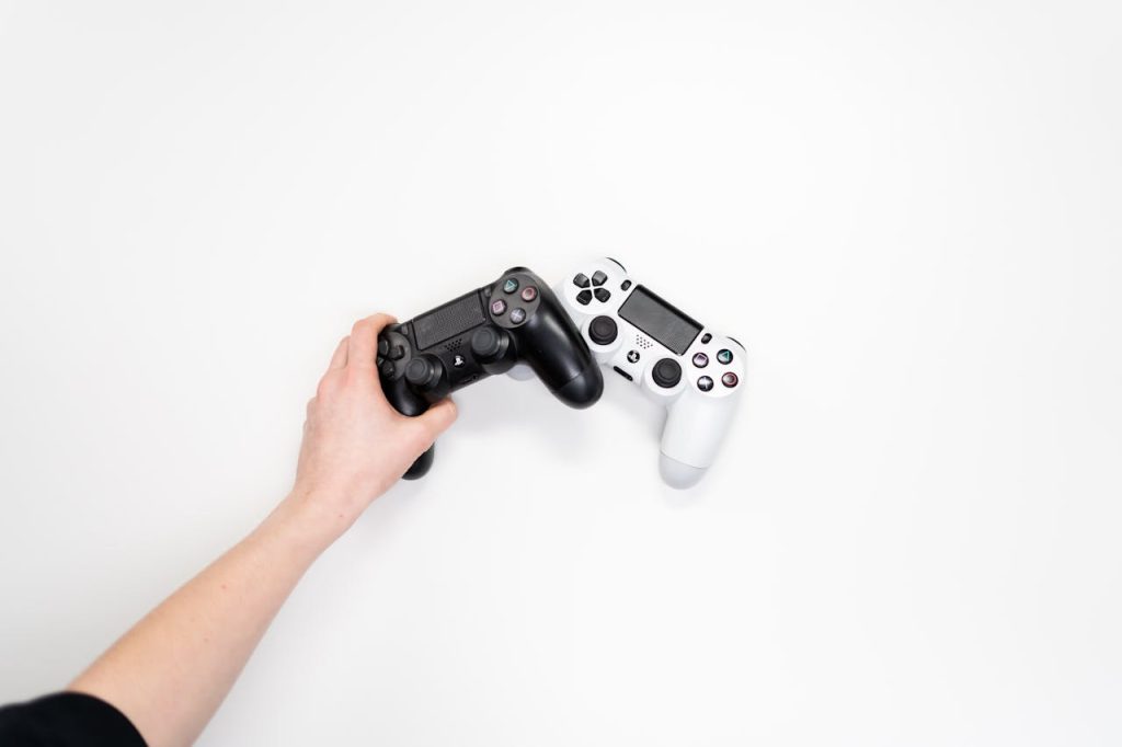 Black and white gaming controllers on a white background, emphasizing minimalism.